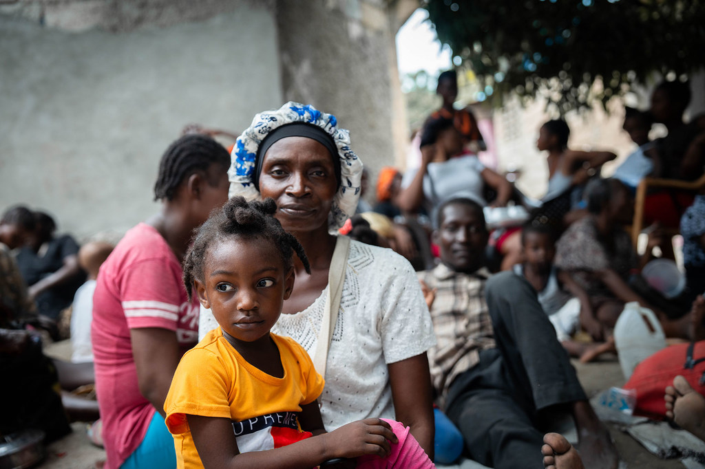 A mother sits with her child at a site for displaced people in Haiti.